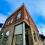 Halfway OR 19 A two-story brick and stone building with large windows houses a US Bank branch in Halfway, OR. A blue US Bank ATM sign hangs from the upper corner. The sky is clear and blue with a few clouds.